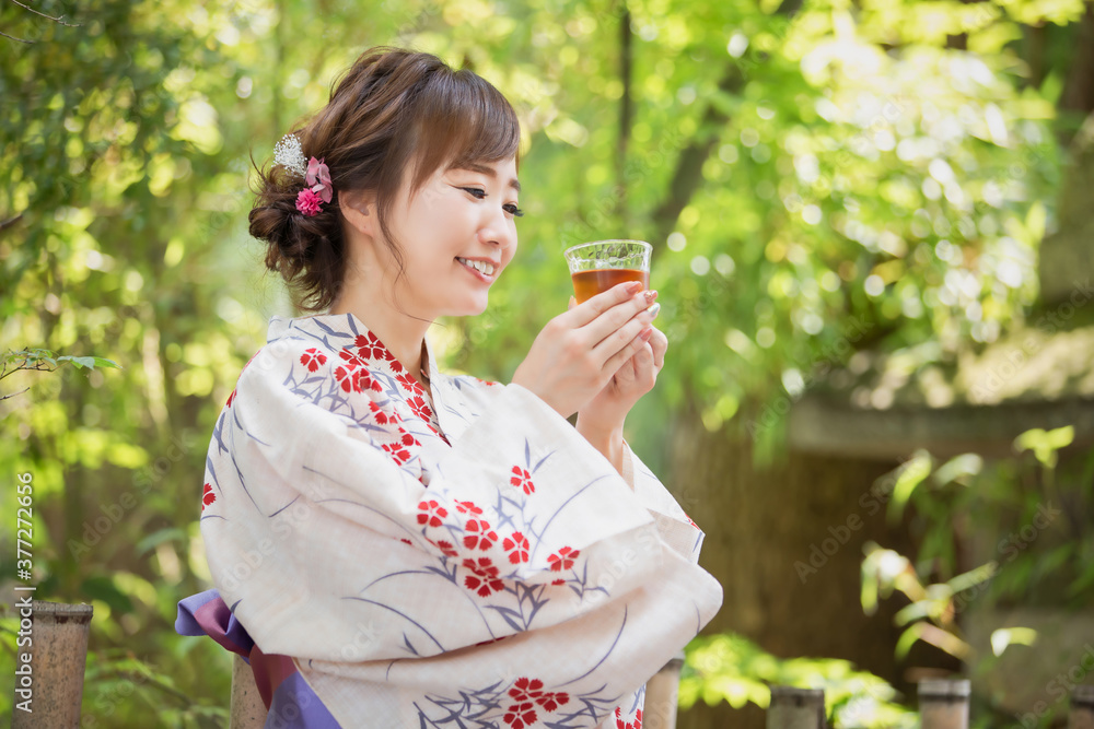 飲み物を飲む浴衣姿の女性
