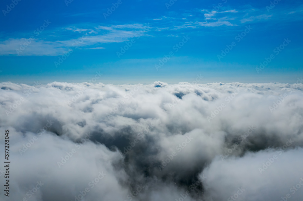 Cotton clouds below and sapphire sky above. Fluffy endless clouds.