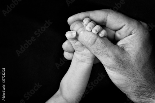Obraz na płótnie mano de bebé sosteniendo mano de adulto en blanco y negro
w salonie
