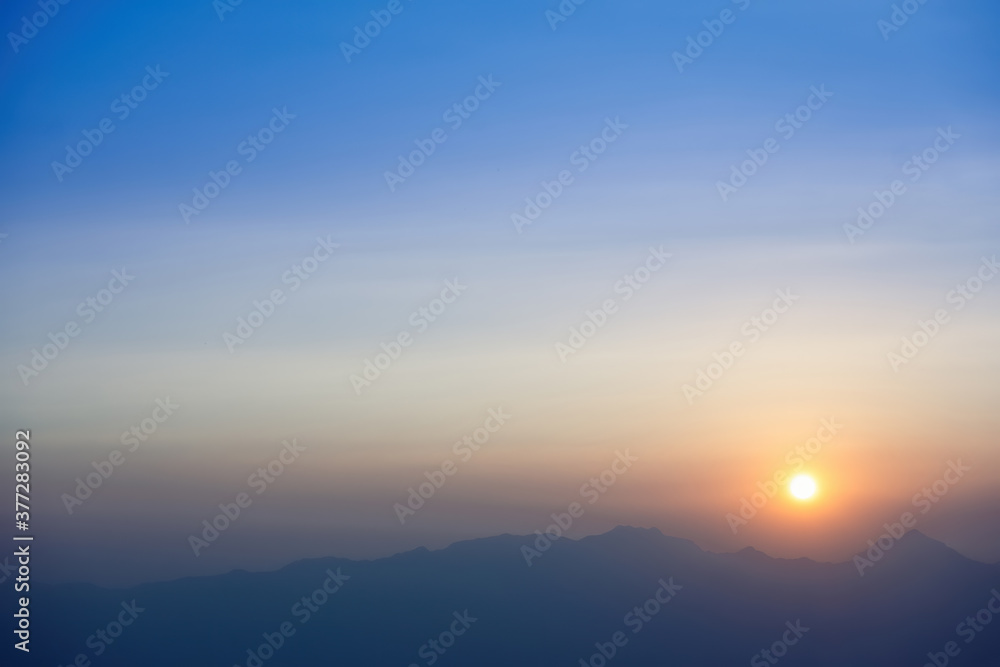 sunset view from the mountain top.photo has focused on a tree branch and partly blur on other subject