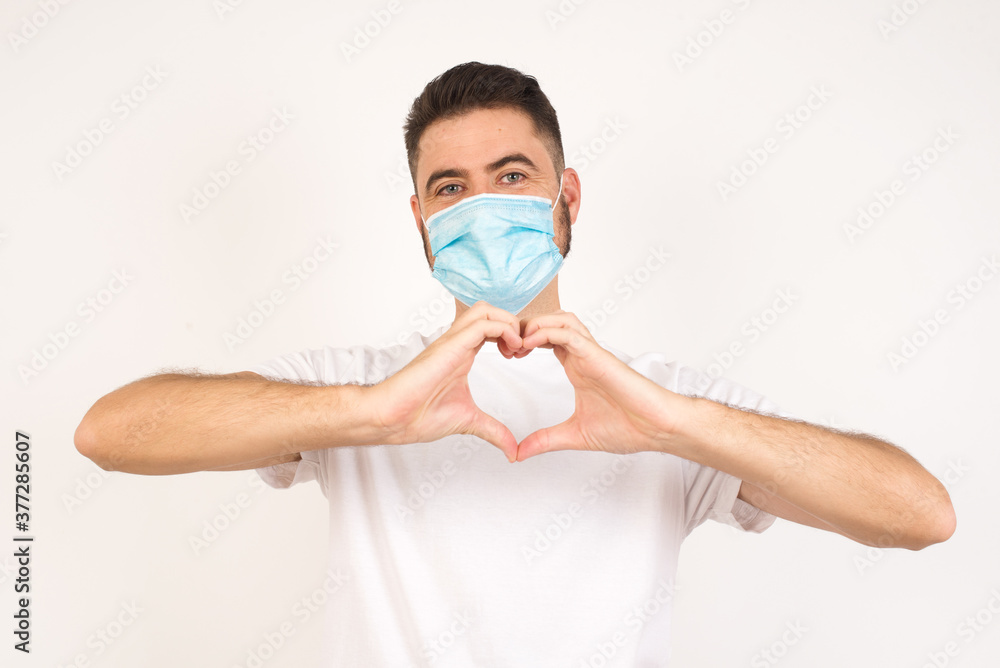 Beautiful caucasian man over isolated background smiling in love showing heart symbol and shape with hands. Romantic concept. Beautiful caucasian man over isolated background smiling in love showing heart symbol and shape with hands. Romantic concept.