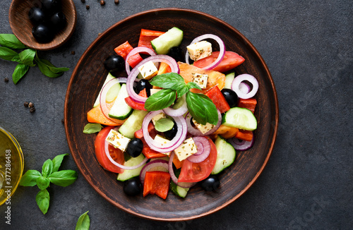 Classic Greek salad with feta on a wooden background.