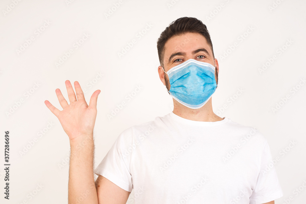 Young handsome man standing over yellow isolated background Waiving saying hello or goodbye happy and smiling, friendly welcome gesture Young handsome man standing over yellow isolated background Waiving saying hello or goodbye happy and smiling, friendly welcome gesture