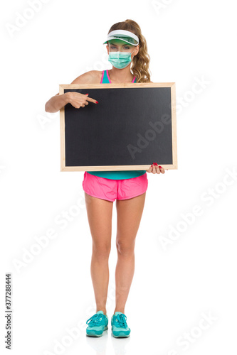 Smiling Girl Holding Blackboard And Pointing