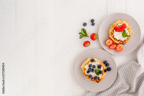 Traditional belgian waffles on white wood table background top view
