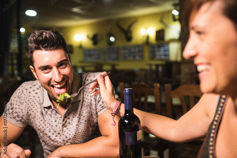 Couple having fun with salad in restaurant. Valentines date