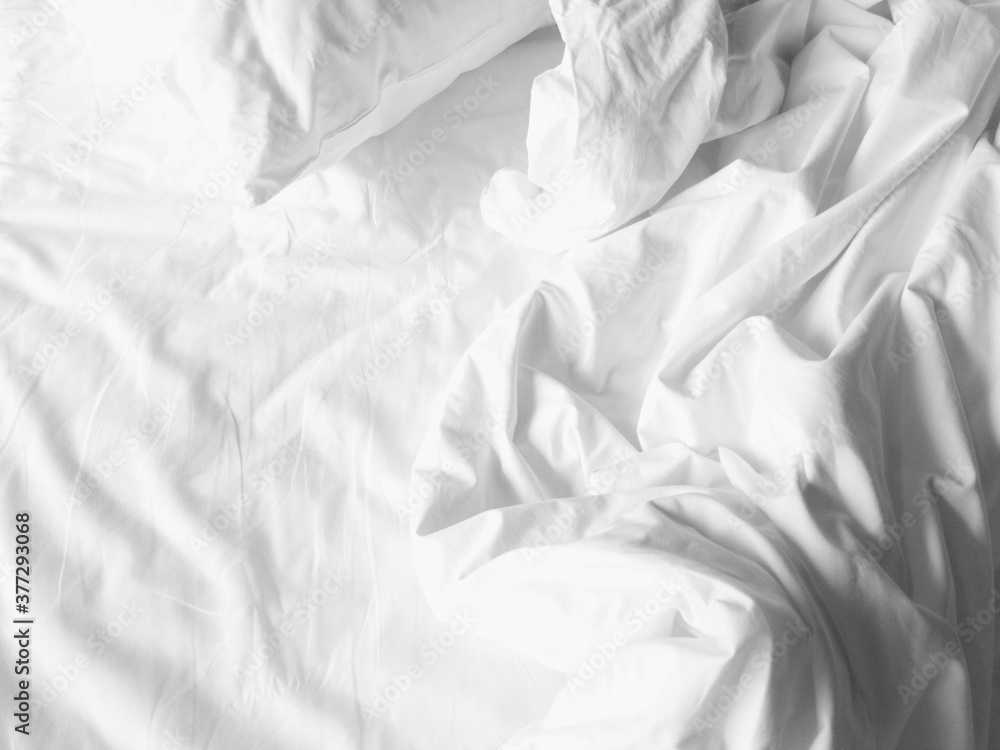Soft and calm atmosphere image of all white bed room. Pillows and blanket on empty bed, close up Soft and calm atmosphere image of all white bed room. Pillows and blanket on empty bed, close up