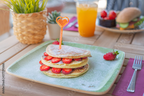 Close-up delicious pancakes with fresh strawberries and chocolate sauce. Breakfast concept.