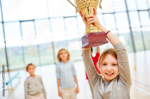 Mädchen hält stolz den Siegerpokal photo