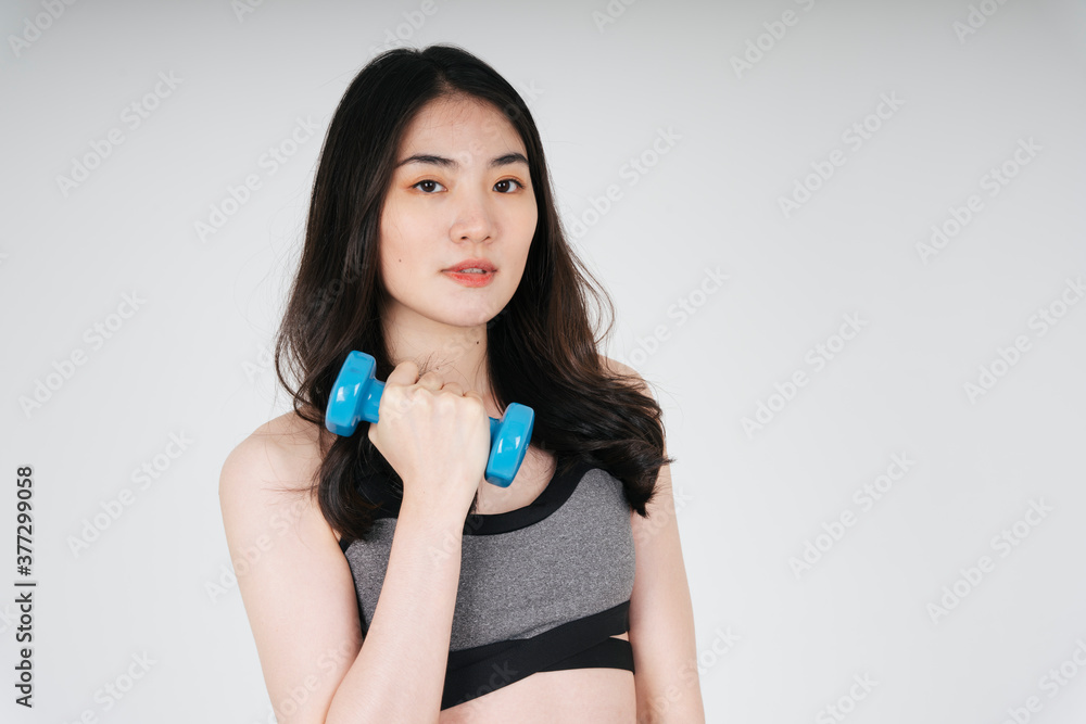 Beautiful slim asian woman work out with dumbbell over white background.