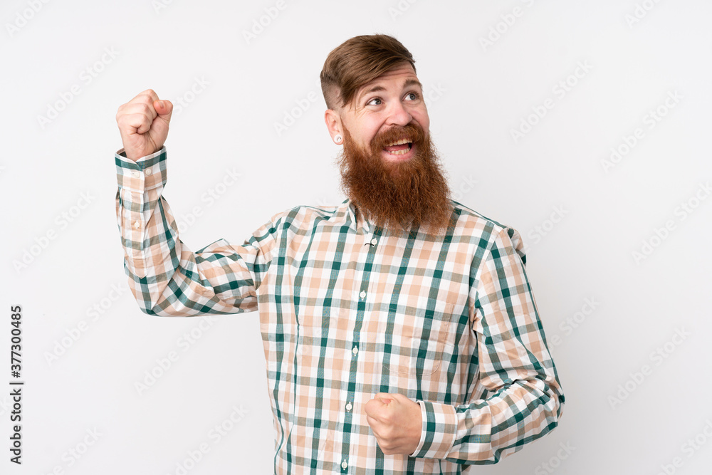 Redhead man with long beard over isolated white background celebrating a victory Redhead man with long beard over isolated white background celebrating a victory