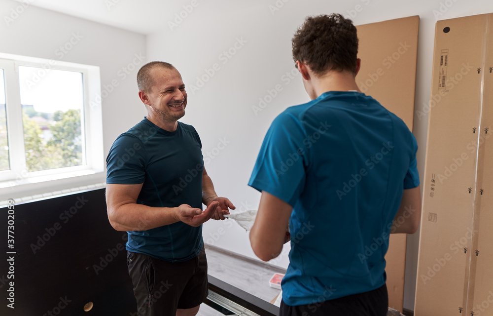 Father and son assembling furniture in new home Father and son assembling furniture in new home