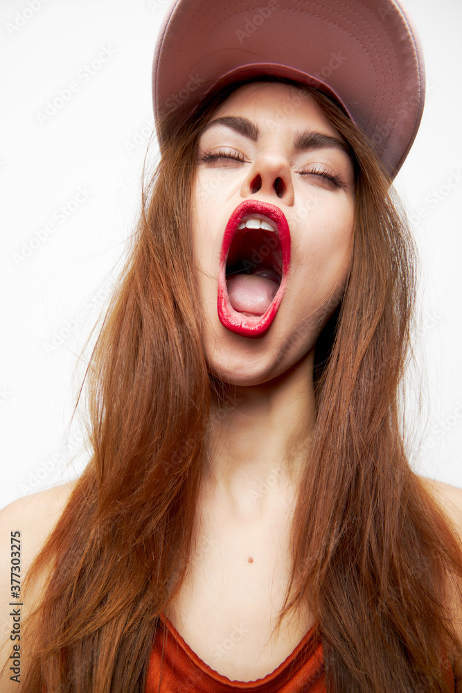 Woman in a cap Opens his mouth wide with fun emotions closed eyes orange dress Woman in a cap Opens his mouth wide with fun emotions closed eyes orange dress