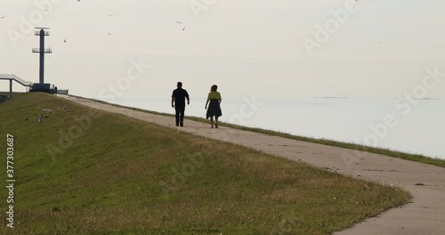 Pedestrians walking on the dike photo