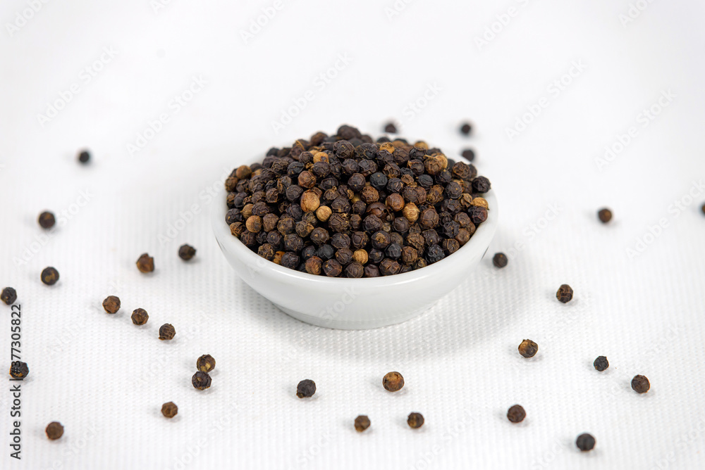 black pepper in white bowl on white canvas background black pepper in white bowl on white canvas background