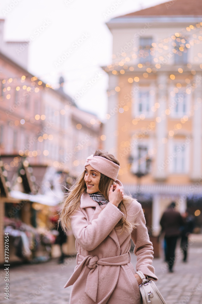 Girl walks on the street of the Christmas market, decorated for Christmas Girl walks on the street of the Christmas market, decorated for Christmas