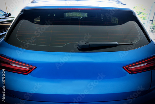Fotomurale Image of Rear view of blue car with rear wiper, defogger wires and rear lights o