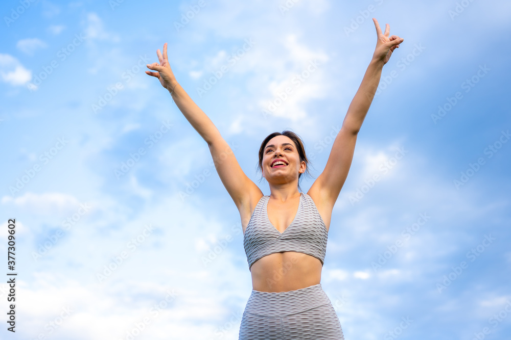 Fitness session with a young Caucasian blonde, very cheerful doing exercises, with the sky in the background, symbol of vistoria, gray sport suit, fit girl, healthy life, exercise in the field Fitness session with a young Caucasian blonde, very cheerful doing exercises, with the sky in the background, symbol of vistoria, gray sport suit, fit girl, healthy life, exercise in the field