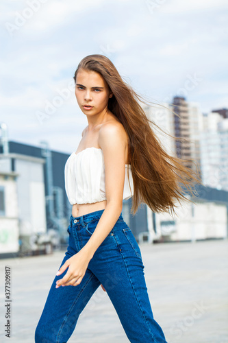 Close up portrait of a young woman in blue jeans