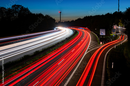 Autobahn Deutschland Sauerlandlinie A 45 Kurve Dämmerung Langzeitbelichtung Lichtspuren Verkehr Autos LKW Windrad Erneuerbare Energien Blaue Stunde Feierabend Fahrstreifen Asphalt Parkplatz rot Himmel photo