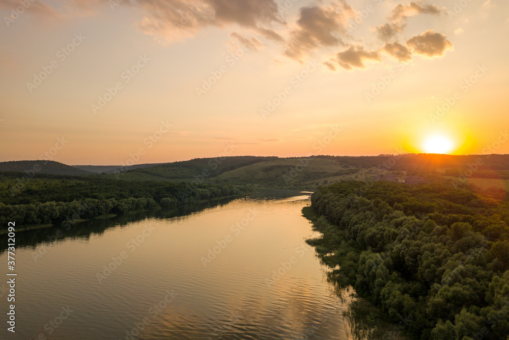 Aerial view of sunset over wide Dnister river and distant rocky hills in Bakota area, part of the National park 