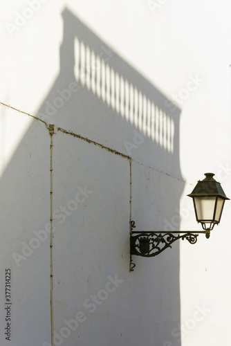 lamppost and shadow of a railing in Olhao, Algarve, Portugal photo