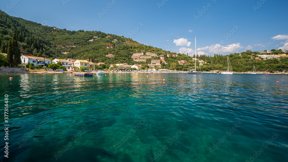 The clear waters of Kalami Bay, in Corfu, Greece, on a bright summers day