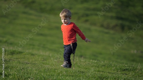 Blond hair child rising up from grass