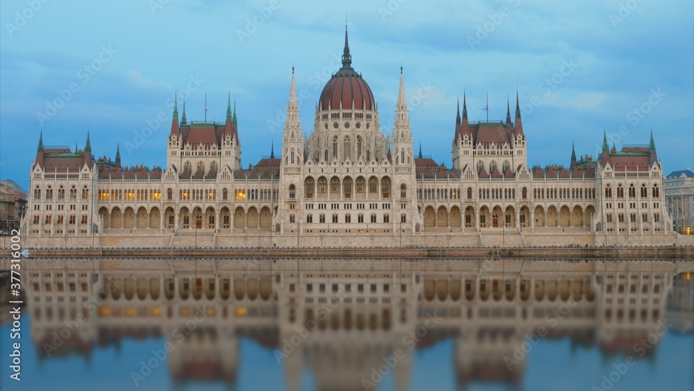 Budapest Parliament mirrored in Danube River at evening