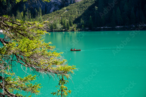 Hombre con perro en un barca en Lago di Braies photo