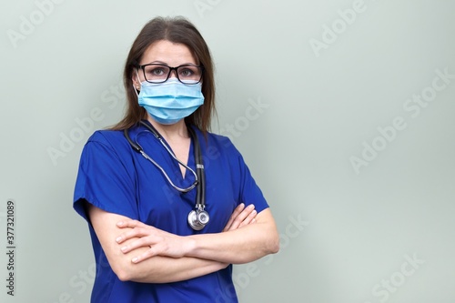 Portrait of confident female doctor with stethoscope mask in blue uniform
