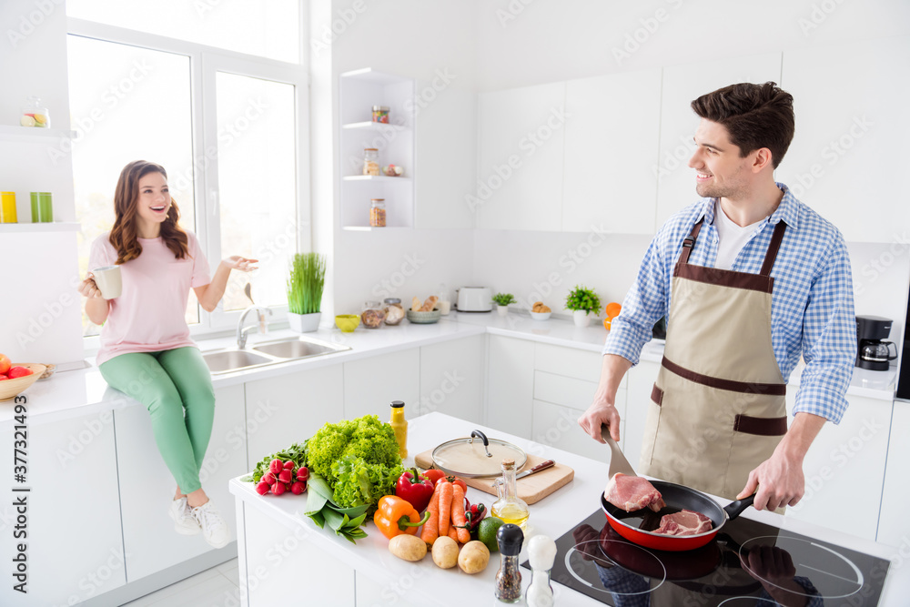 Portrait of two nice lovely attractive cheerful cheery spouses making domestic tasty yummy homemade dish having fun in light white interior kitchen house apartment indoors Portrait of two nice lovely attractive cheerful cheery spouses making domestic tasty yummy homemade dish having fun in light white interior kitchen house apartment indoors