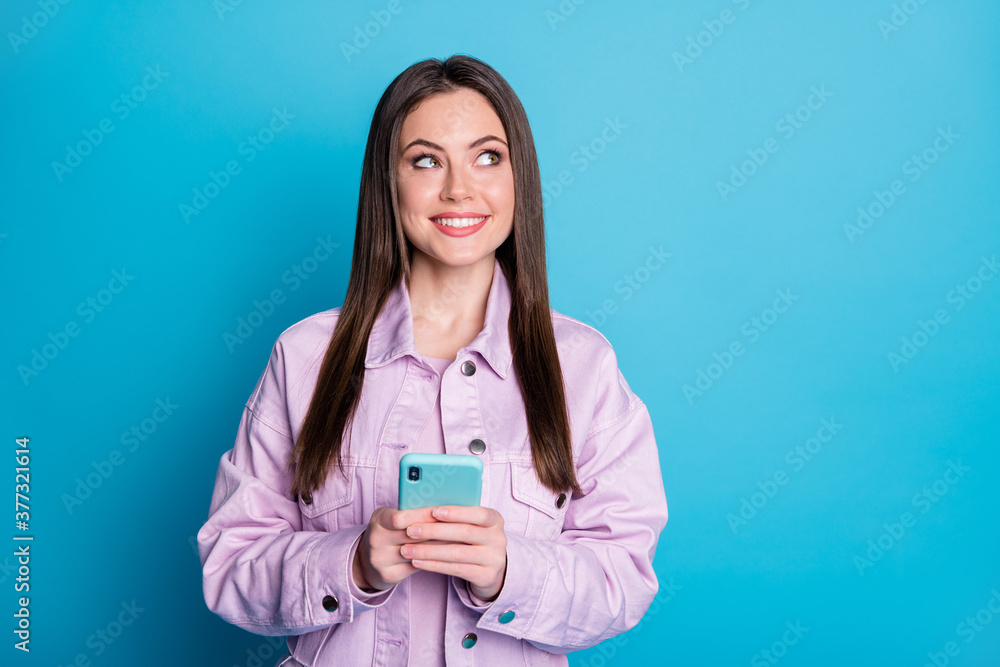 Photo of attractive charming lady hold telephone writing new post blog look up interested empty space wear casual denim violet jacket sweater isolated blue color background Photo of attractive charming lady hold telephone writing new post blog look up interested empty space wear casual denim violet jacket sweater isolated blue color background