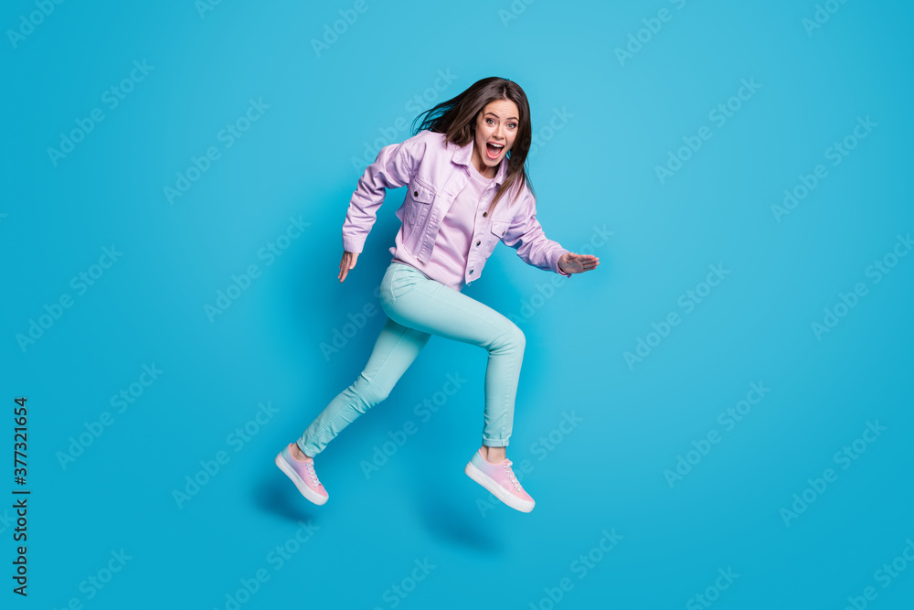 Full size profile photo of funny lady jump up running speed fast rushing shopping center sale season wear casual denim violet jacket sweater pants shoes isolated blue color background