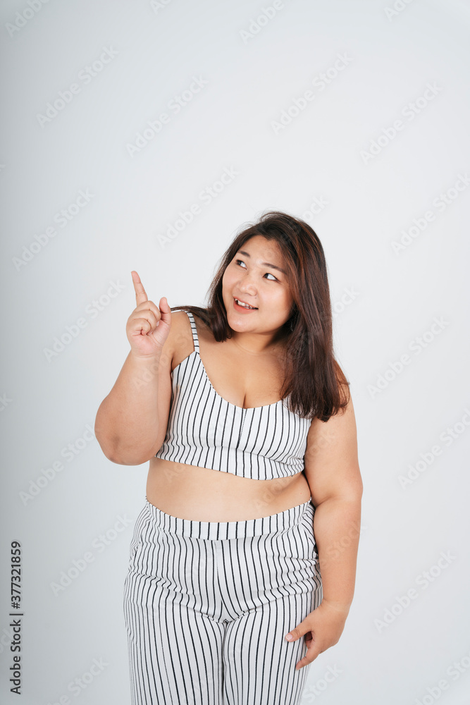 Healthy asian chubby woman pointing at product on white background. Healthy asian chubby woman pointing at product on white background.