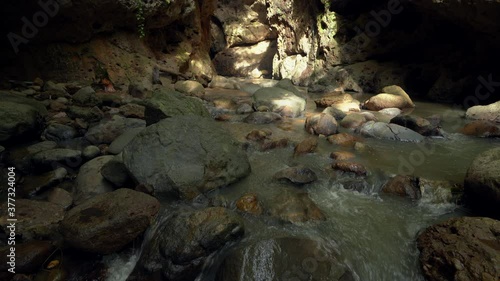 Clear rivulet and rocks during the day In the forest photo