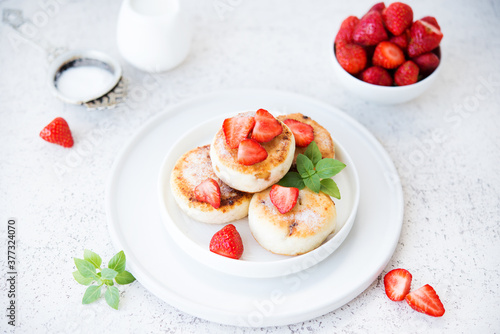 Curd cheesecakes with strawberries and powdered sugar, dessert