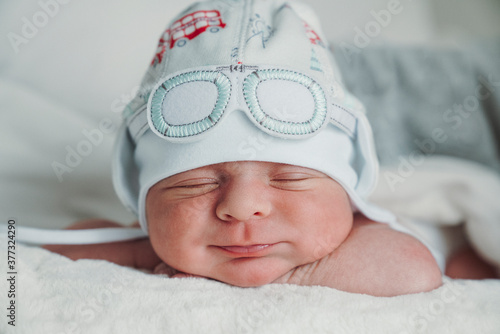 Obraz na płótnie Bebe durmiendo sonriendo con gorro de tela w salonie