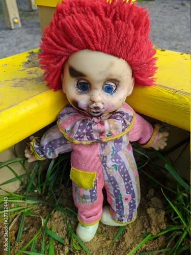 scary toy clown with red hair in the sandbox photo