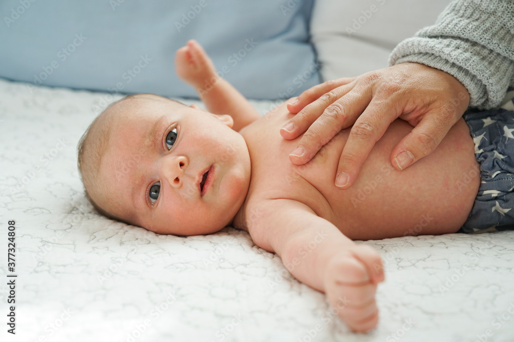 Mano de adulto calmando a un bebe en su cuna