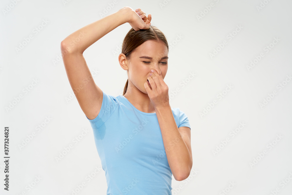 woman with sweaty armpit covering nose bad smell hygiene