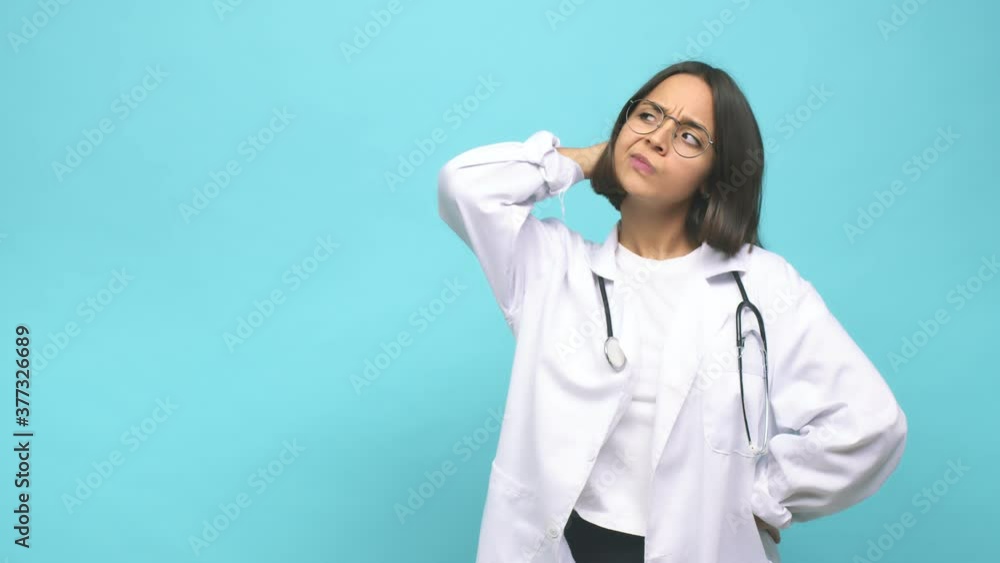 Young doctor indian woman touching back of head, thinking and making a choice Young doctor indian woman touching back of head, thinking and making a choice