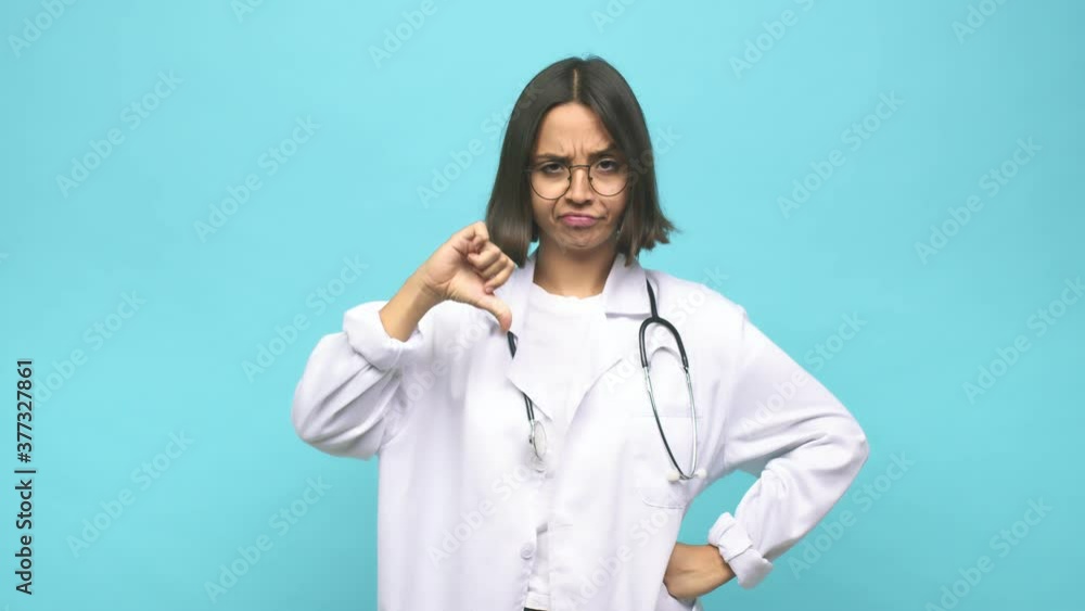 Young doctor indian woman showing a dislike gesture, thumbs down. Disagreement concept. Young doctor indian woman showing a dislike gesture, thumbs down. Disagreement concept.