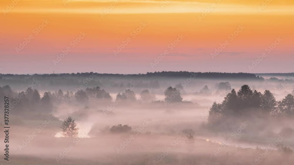 Amazing Sunrise Over Misty Landscape. Scenic View Of Foggy Morning Sky With Rising Sun Above Misty Forest And River. Early Summer Nature Of Eastern Europe. 4K Amazing Sunrise Over Misty Landscape. Scenic View Of Foggy Morning Sky With Rising Sun Above Misty Forest And River. Early Summer Nature Of Eastern Europe. 4K