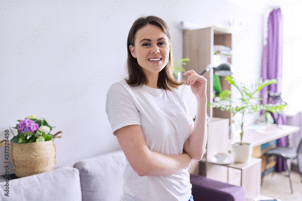 Portrait of happy smiling young woman looking at the camera in home Portrait of happy smiling young woman looking at the camera in home