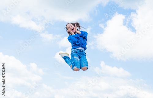 happy childrens day. free your imagination. kid beauty and fashion. child jump in casual style. Child jumping on background of sky. summer holiday concept. childhood happiness. She got great style