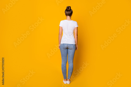 Back rear spine behind view photo of charming pretty youth woman stand good look wear gumshoes millennial style clothes isolated over shine color background