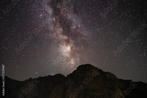 Beautiful night landscape   huge cliff   starry sky with bright milky way galaxy. Night landscape. Astronomical background.