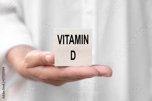 Doctor advises. Nutritionist or medical worker holds a VITAMIN D sign, healthy lifestyle concept.