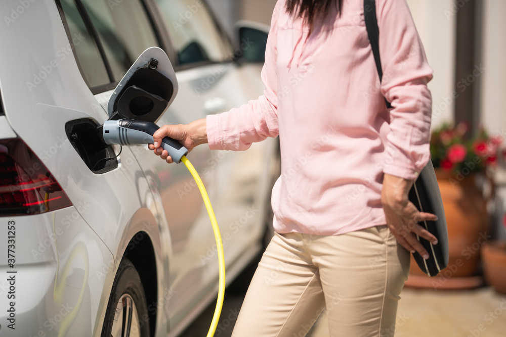 Woman charging electric car Woman charging electric car